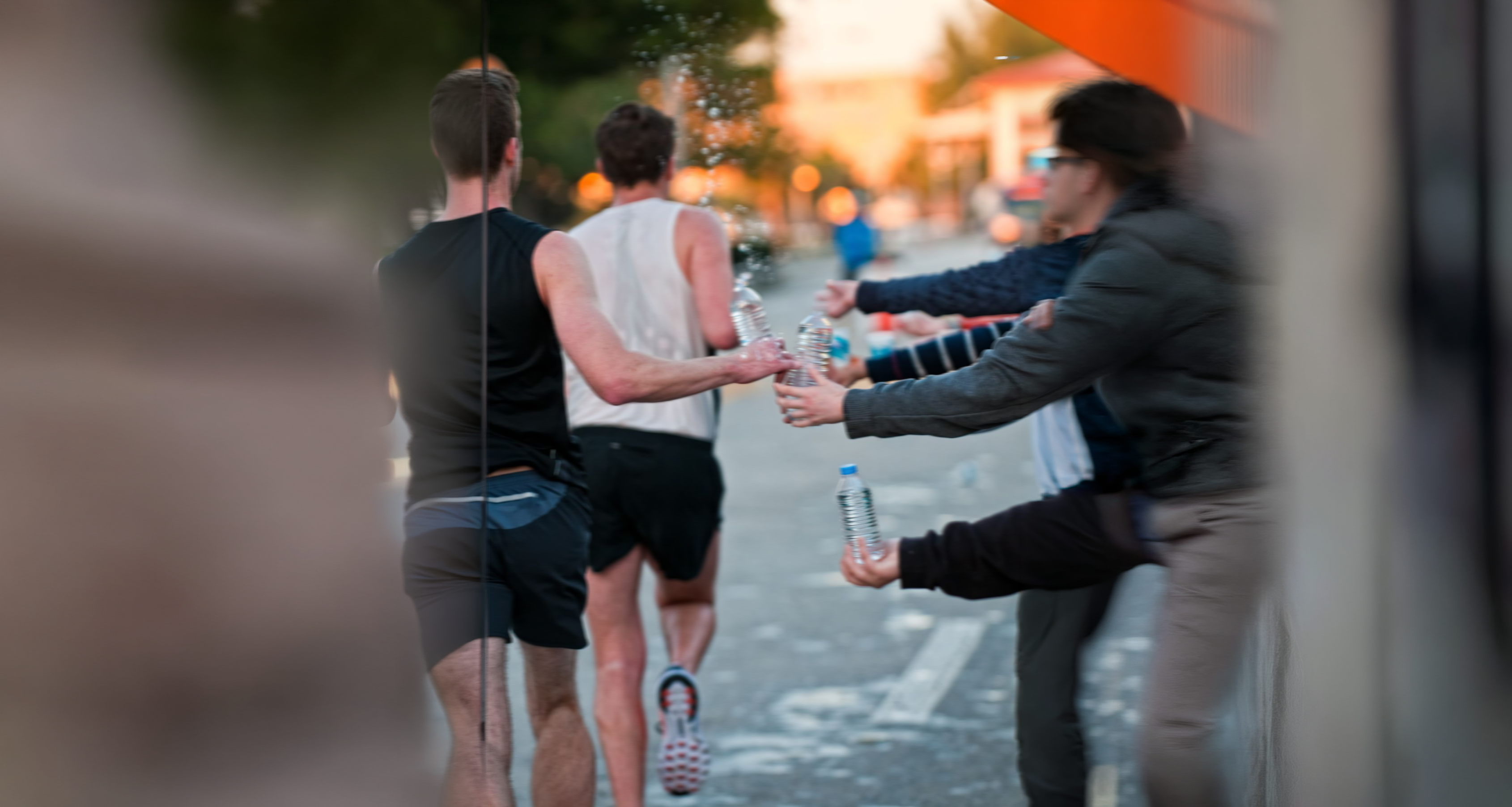 Personer sender flasker videre under et løp